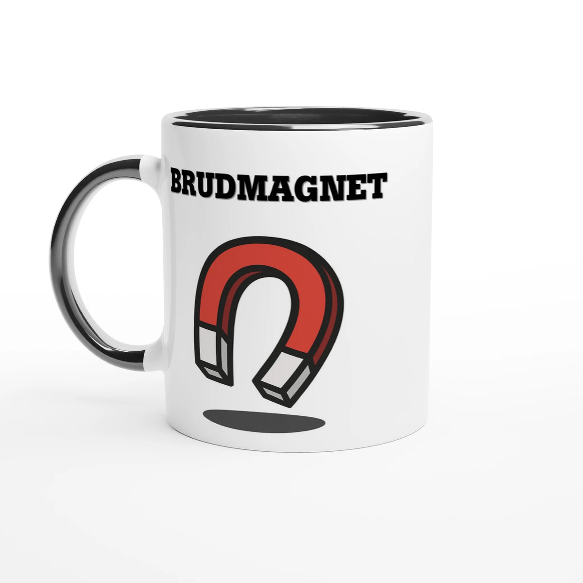 Vit mugg med svart handtag och svart insida med texten Brudmagnet och en röd och vit hästskomagnet