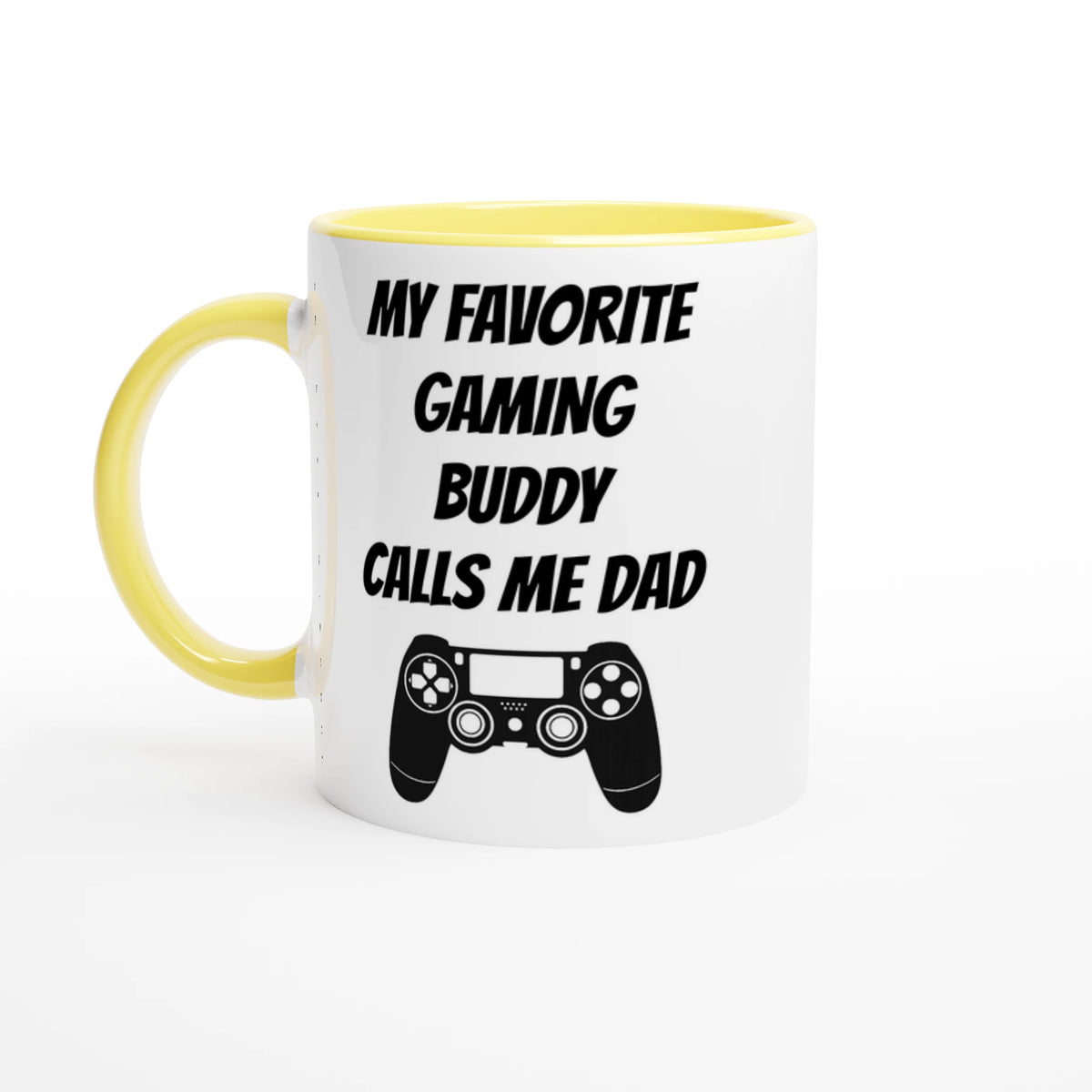 Vit mugg med gult handtag och gul insida med texten My favorite gaming buddy calls me dad och en spelhandkontroll