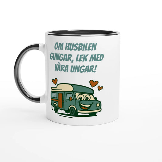 Vit mugg med svart handtag och svart insida med texten Om husbilen gungar, lek med våra ungar! och en glad tecknad husbil med hjärtan